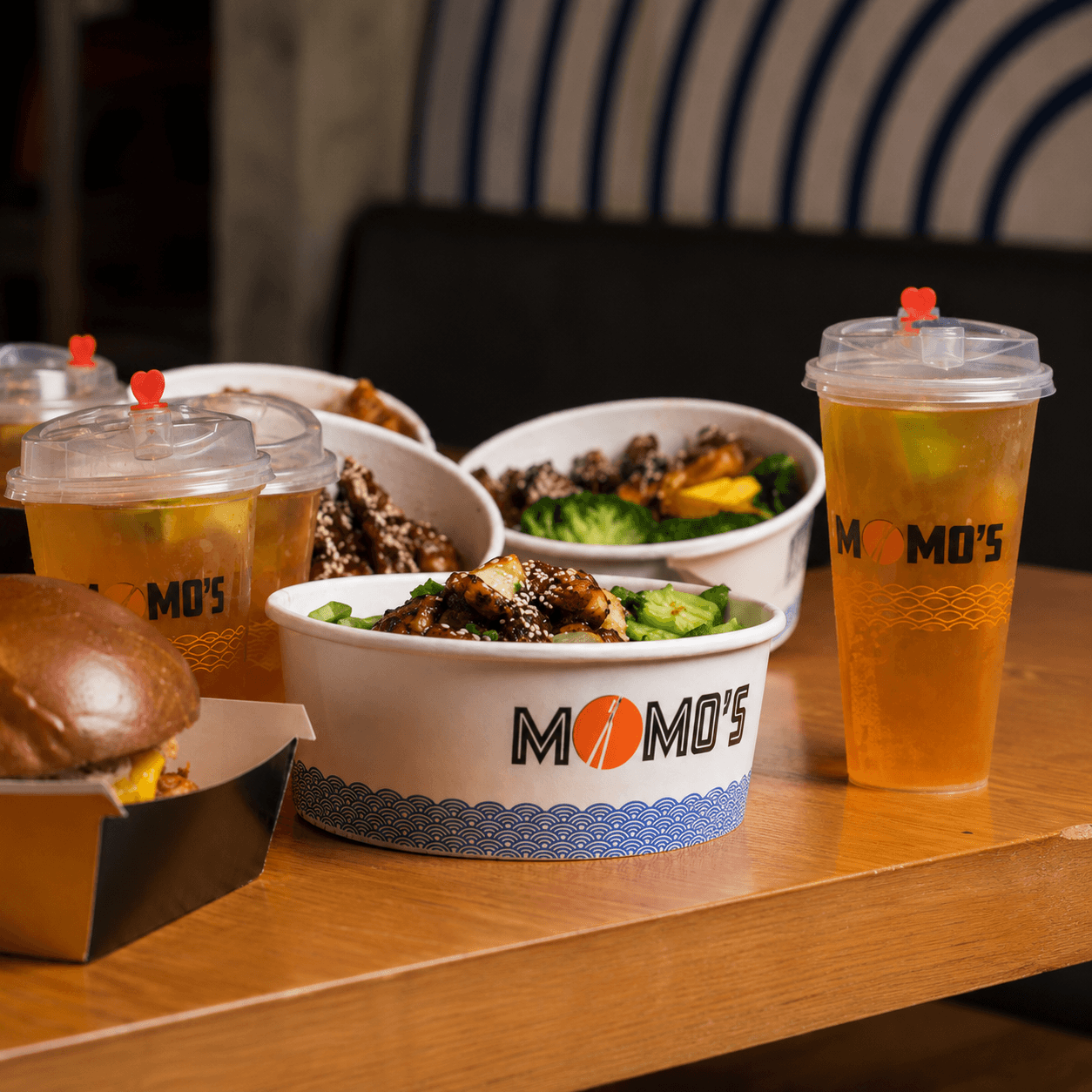 Momo’s custom branded takeaway packaging featuring printed food bowls, cold drink cups and food boxes.