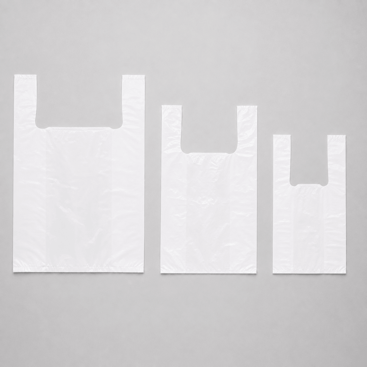 White plastic carrier bags in three sizes for takeaway and food service use