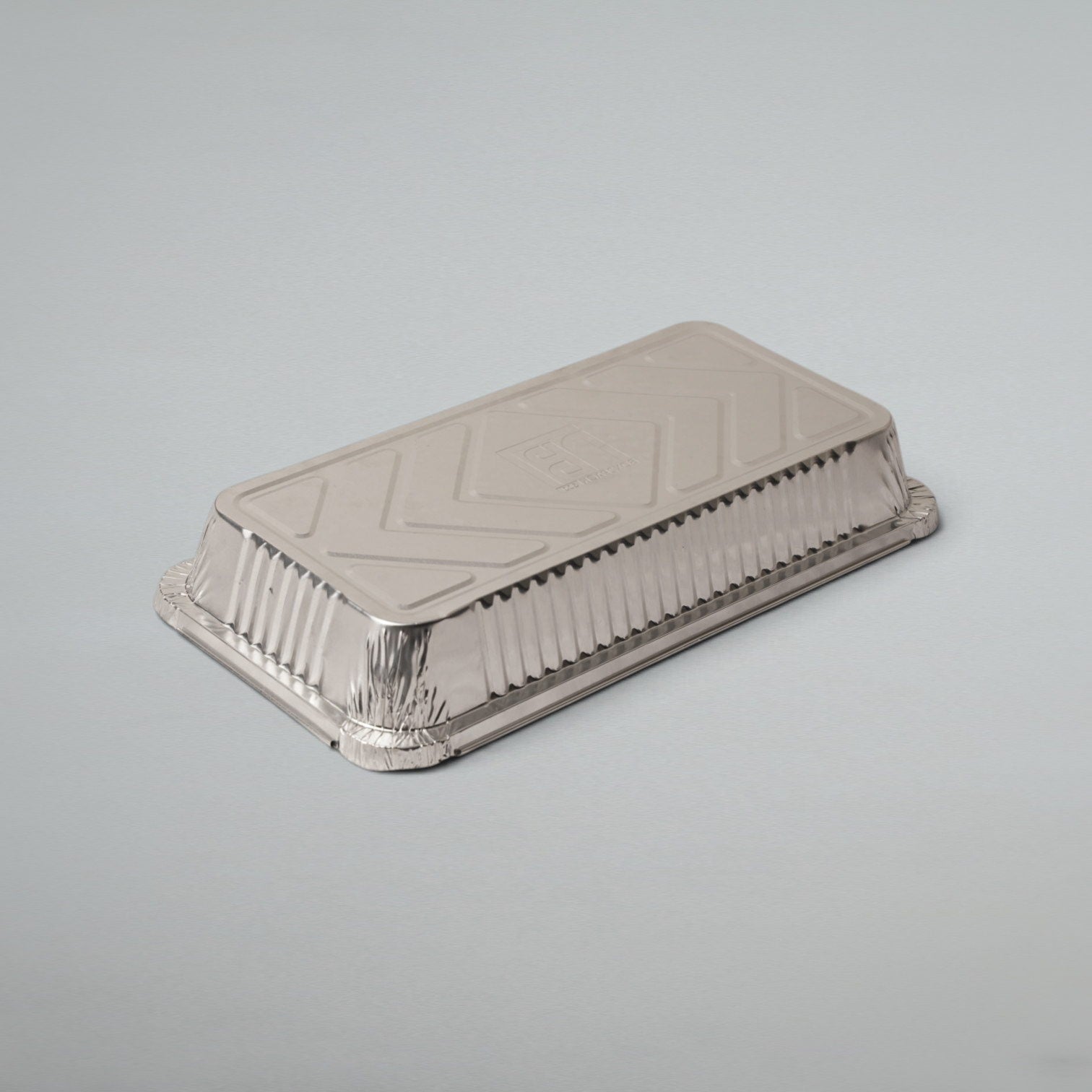 A rectangular disposable aluminum food tray with a fitted lid, shown on a plain light gray studio background.