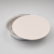 A 9 inch round silver aluminum pie tin with a smooth, light beige circular insert or lid resting on top, photographed on a neutral light gray background.