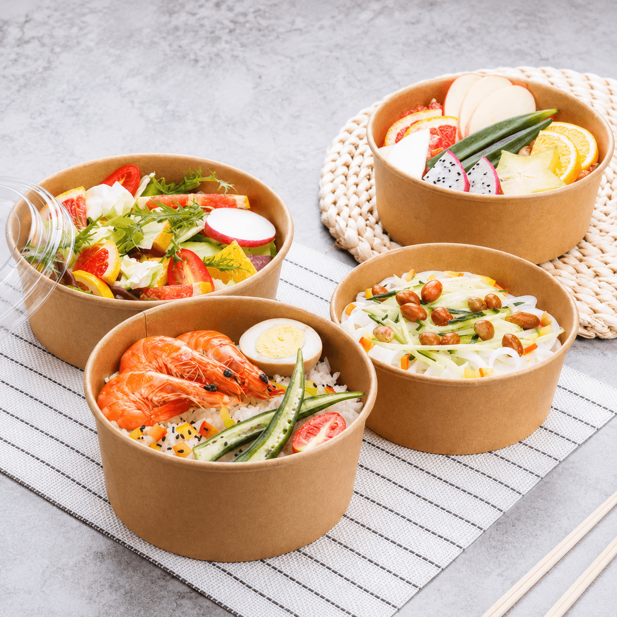 Kraft round takeaway food bowls filled with salads, rice and fresh food for catering and food delivery.