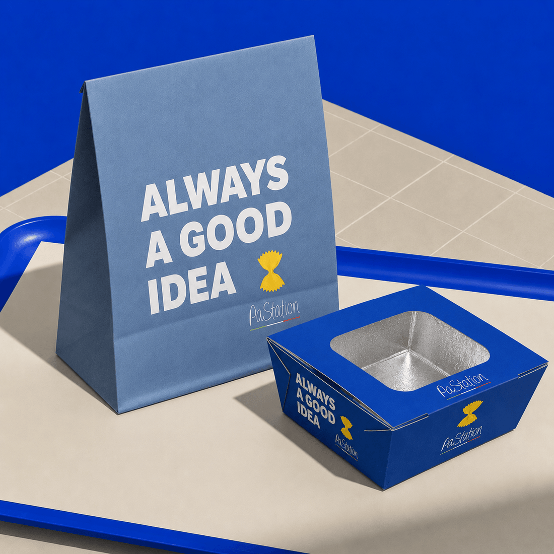 PaStation custom branded takeaway packaging featuring a blue paper bag and food box with the “Always a Good Idea” design.