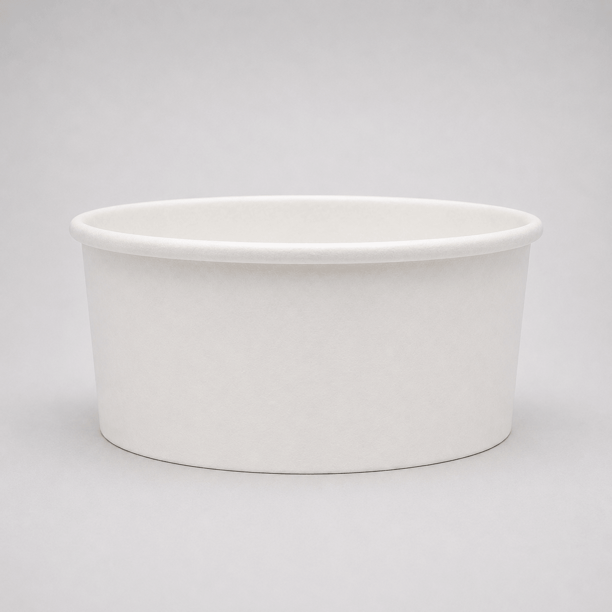 A plain white paper cup with a wide rim, photographed on a seamless light gray studio background.