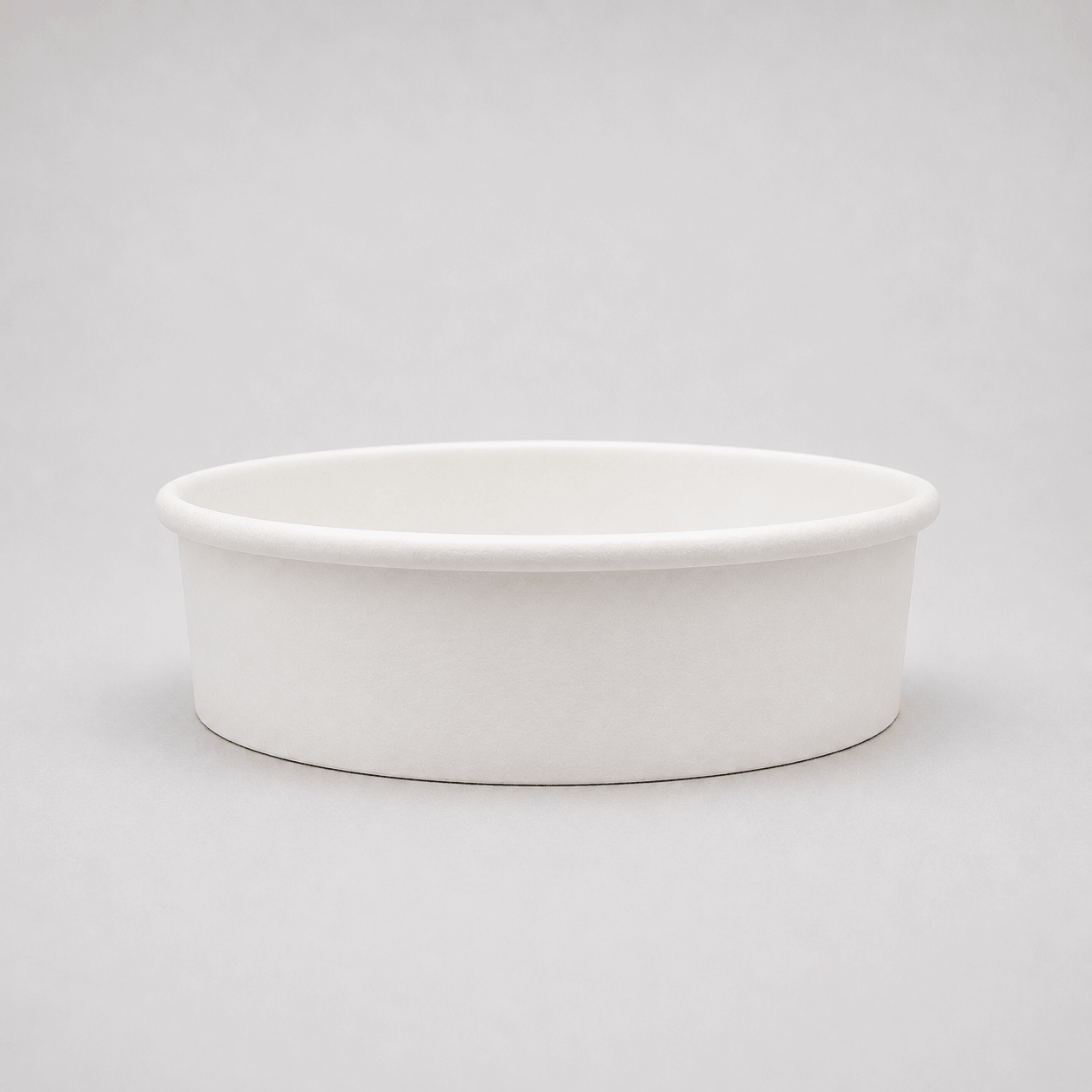 A plain white paper cup with a flared rim, photographed on a seamless light gray studio background.